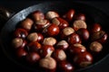 Ripe chestnuts in an old iron pan.