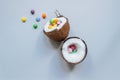 Ripe coconut with colorful sweets on the blue background, top view