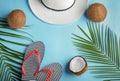 Ripe coconuts, beach hat and flip-flops on color background