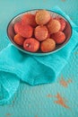 Ripe, colorful lichees decorated on turquoise background with napkin