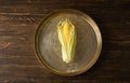 Ripe corn in a tray on a wooden background, view from the top