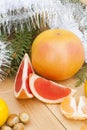 Ripe Cut Red Grapefruit with New Year's and Christmas decoration midst fruits and tinsel