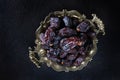 Ripe dates on an old brass platter. Juicy dried fruits. Healthy food. Fast food. Food for vegetarians. Top view