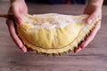 Ripe durian in hand on wooden table