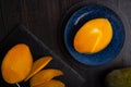 Ripe egyption cutting Mango served at blue and black plate at black table. close up. flat lay Royalty Free Stock Photo