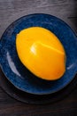Ripe egyption cutting Mango served at blue plate at black table. close up. flat lay Royalty Free Stock Photo