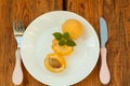 Ripe fresh apricot fruits on a white plate on the wooden background. Copy space, delisious healthy food