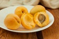 Ripe fresh apricot fruits on a white plate on the wooden background. Copy space, delisious healthy food. Royalty Free Stock Photo