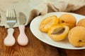 Ripe fresh apricot fruits on a white plate on the wooden background. Copy space, delisious healthy food. Royalty Free Stock Photo