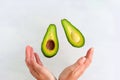 avocado slices fly into women`s hands on white background Royalty Free Stock Photo