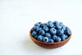 Ripe fresh blueberries in a wooden bowl on white background. Royalty Free Stock Photo