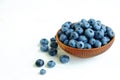 Ripe fresh blueberries in a wooden bowl on white background. Royalty Free Stock Photo