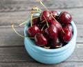 Ripe fresh cherries in a blue bowl. Food background. Red juicy cherry berry on grey wooden background Royalty Free Stock Photo