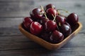 Ripe fresh cherries in a wooden bowl. Food background. Red juicy cherry berry on grey wooden background. Cherries in a Royalty Free Stock Photo