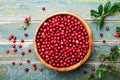 Ripe fresh cowberry lingonberry, partridgeberry, foxberry in wooden bowl on rustic vintage table from above.