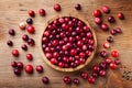 Ripe fresh cranberry in wooden bowl on rustic table top view Royalty Free Stock Photo