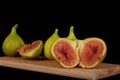 Ripe fresh figs are lying on a wooden cutting board.