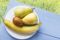 Ripe fresh fruits on wooden blue table and on natural grasses background. Banana, kiwi fruit and pear for healthy nutrition. Rusti Royalty Free Stock Photo