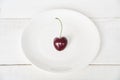 Ripe fresh juicy berry on a white background. One heart-shaped cherry on a white plate. Fruit background. valentine