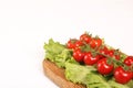 Ripe fresh Juicy organic brunch of cherry tomatoes on cutting board with Green Lettuce on a white table