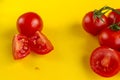 Ripe fresh Juicy organic cherry tomatoes on branch and cut tomato on yellow plastic cutting board. Top view. Royalty Free Stock Photo