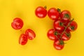 Ripe fresh Juicy organic cherry tomatoes on branch and cut tomato on yellow plastic cutting board. Top view. Royalty Free Stock Photo