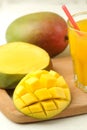Ripe fresh mango fruit and slices and mango juice in a glass on a light background. tropical fruit. close-up Royalty Free Stock Photo