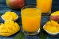 Ripe fresh mango fruit and slices and mango juice in a glass on a blue wooden table. tropical fruit Royalty Free Stock Photo