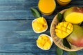 Ripe fresh mango fruit and slices and mango juice in a glass on a blue wooden table. tropical fruit. top view Royalty Free Stock Photo