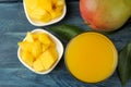 Ripe fresh mango fruit and slices and mango juice in a glass on a blue wooden table. tropical fruit. top view Royalty Free Stock Photo