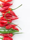 Ripe fresh organic red and green hot peppers arranged in border on white stone marble background. Healthy spices digestion Royalty Free Stock Photo