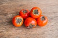 Ripe fresh persimmon on wood board. Food ingredient.