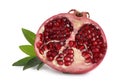 Ripe fresh pomegranate half with juicy seeds and green leaves on white background