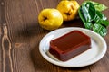 Ripe fresh quince fruits with green leaves and traditional homemade quince jam on the wooden table