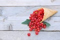 Ripe fresh red currants in ice cream waffle cone on rustic wooden background Royalty Free Stock Photo