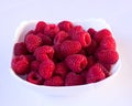 Ripe fresh red raspberries in a white plate on a white background Royalty Free Stock Photo