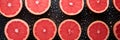 ripe fresh sliced red grapefruit in drops of water on black background top view banner Royalty Free Stock Photo