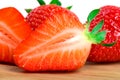 Ripe fresh strawberries, whole and cut into slices on a wooden Board very close-up with an isolated white background