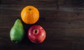 Orange, red apple and green pear on the table, top view. Royalty Free Stock Photo