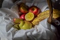 ripe fruits red apples, green pear, cut lemons, bananas in a basket with a white drapery with folds, apple Royalty Free Stock Photo