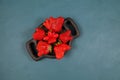Ripe funny strawberry berries on wooden plate, top view. Blue background, copy space. Ugly fruits and vegetables can be eaten.