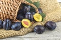Ripe garden plums and leaves in basket on a wooden table. Harvesting season. Fresh plums Royalty Free Stock Photo