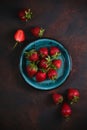 Ripe garden strawberry in blue plate on dark stone table Royalty Free Stock Photo