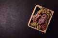 Ripe grapes branches in rustic basket on dark wooden background. Top view. Copy space. Harvesting and healthy eating concept Royalty Free Stock Photo