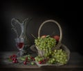 Ripe grapes, a glass of wine and autumn berries on the table Royalty Free Stock Photo