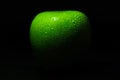 Ripe green apple with water drops on a black background. Food concept Royalty Free Stock Photo