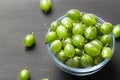 Ripe green gooseberries in a glass transparent bowl and jar on a black  background. Harvest concept agrus. Vegetarian food.Top Royalty Free Stock Photo