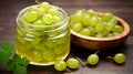 Ripe green gooseberries in a glass transparent bowl and jar on a wooden background. generative ai Royalty Free Stock Photo