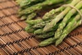 Ripe green mini asparagus on wooden mat