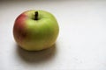 Ripe green red apple on the white table Royalty Free Stock Photo